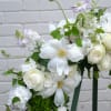 A beautiful wreath of seasonal blooms in white and greens.