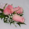 This beautiful corsage features three light pink roses along with a light