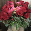 Romantic arrangement of red roses, spray roses, alstromeria, tulips, peonies (when in