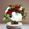 A festive holiday mix of roses, hydrangea, berries and pinecones in a