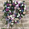 This beautiful and petite, heart-shaped wreath of sky blue touches, lavender and
