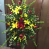 easel spray with yellow lilies, snaps and buttons with red roses bells