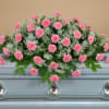 A beautiful half casket spray of pink carnations and babies breath.