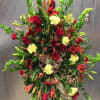 standing easel spray with bells of Ireland red roses and lilies and