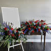 This deluxe casket spray is accompanied by an easel with floral accent