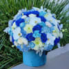 This blue-themed floral arrangement with blue hydrangeas, roses, and carnations, complemented by