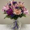 This arrangement contains Pink Lilies, Peach Disbuds and Purple Statis.  