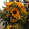 Sunflowers snd yellow Daiseys adorned with yellow holler in a clear vase.
