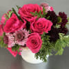 This stunning floral piece is arranged on a ceramic vase. This piece