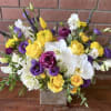 Lush seasonal flowers including sweet peas, orchids, hydrangeas, yellow roses and spray