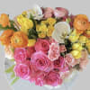 This arrangement includes pink roses, yellow spray roses, orange ranunculus and white
