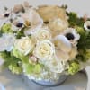This crisp white and green arrangement includes roses, anemones , hydrangeas and