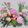 A bush like arrangement, has roses, tulips, peonies, and ranunculus. All very