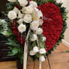 This gorgeous design of red carnations on a full heart with weeping