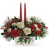 The holiday table shines with this festive centerpiece of roses and winter
