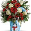 Cheerful gerberas and Christmas greens look even more festive arranged in this