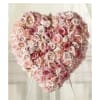 Delicate pink roses and carnations fill this heart shaped arrangement for a