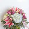 Wild flowers with roses in a glass vase with fruit