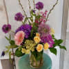 This mixed bloom arragements is accented by sunny sprays of roses, beautifulyy