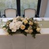 Beautiful phalaenopsis orchid, white roses, carnations, spray roses and greens sweetheart table