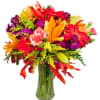 A festival of bright colors in a vase includes lilies, gerber daisies