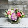 Blush dahlias centerfold this gorgeous low table piece complimented with dusted soft