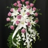 lavender roses, lush white lilies, and dendrobium with mixed greens. Ribbon optional