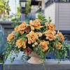 A stunning flower arrangement in a ceramic vase, featuring rich brown caramel