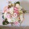 Beautiful and airy white and light pink standard and spray roses, carnations