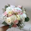 Beautiful and airy white and light pink standard and spray roses, carnations
