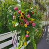 Bringing together Liatris, yellow sunflowers, orange and yellow roses, pink spray roses