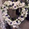 This delicate heart-shaped wreath is made with a lovingly handpicked selection of