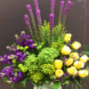 Made with yellow roses, purple stock. green hydrangeas and liatris 