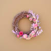 The Lover wreath is a grapevine wreath bursting with preserved colorful flowers.