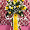 This is a medium cross with yellow roses, white roses, and carnations.