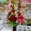 Contains Gladiolus, Orchids, Roses, Stargazer, Dahlia, Cox in a Tall Red Vase