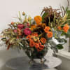 Beautiful combination of oranges and browns arranged in rustic vase. Great gift