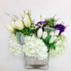 White tulips and hydrangea in a elegant square vase with a splash