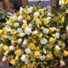 Casket spray has roses and mix greens