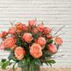 A stunning arrangement of 24 Peachy Blush Roses with local greenery and