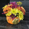 Floral arrangement of colors and seasonal flowers in a ceramic container in
