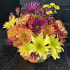 Floral arrangement of colors and seasonal flowers in a ceramic container in