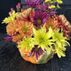 Floral arrangement of colors and seasonal flowers in a ceramic container in