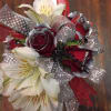 Red roses tipped silver and white alstromaria are accented with black flowers