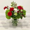Christmas bouquet in a vase with fuzzy green dianthus, spray roses, carnations