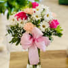 Pink and white floral arranged in a clear vase accented with a