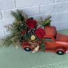 This beautiful truck is filled with christmas flowers, greenery and christmas ornaments.