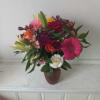 Beautiful fresh deep bright burgundy daisies, various roses and sparkly pink and