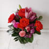 Beautiful orange roses mixed in with pink lilies, purple/pink alstroemeria and light