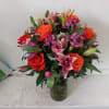 Beautiful orange roses mixed in with pink lilies, purple/pink alstroemeria and light